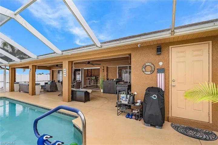 Swimming pool featuring a sunroom, an outdoor hangout area, glass enclosure, and a patio area