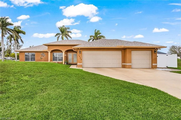 View of front facade with a front yard, stucco siding, and a garage