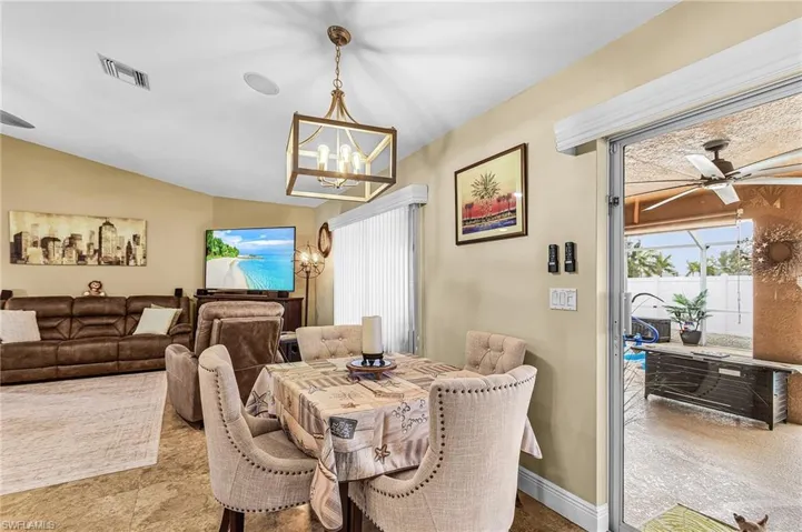 Dining room featuring a ceiling fan, vaulted ceiling, and suspended lighting