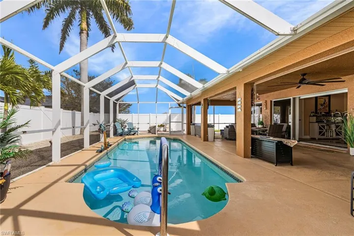 View of swimming pool featuring a sunroom, a fenced backyard, a lanai, and patio surround