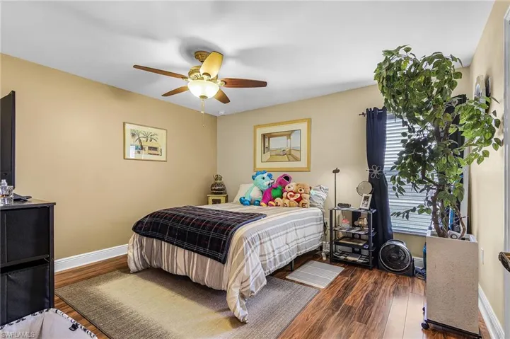 Bedroom with dark wood-style flooring and a ceiling fan
