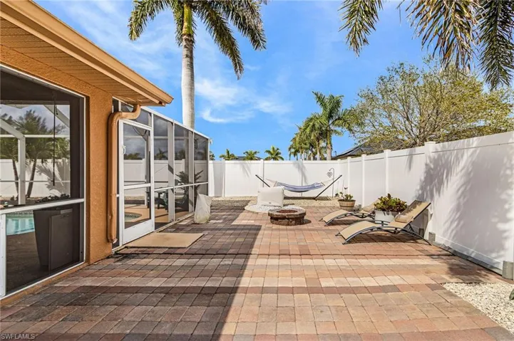 Fenced backyard featuring a fire pit, a patio, a lanai, and a sunroom