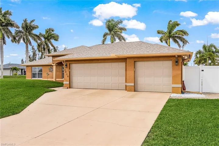 Ranch-style house featuring roof with shingles, an attached garage, a front yard, a gate, and driveway