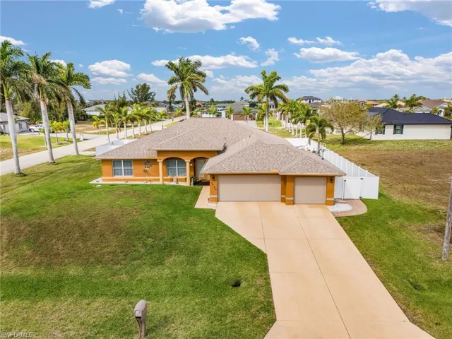 View of front facade featuring a shingled roof, an attached garage, concrete driveway, a residential view, and a gate