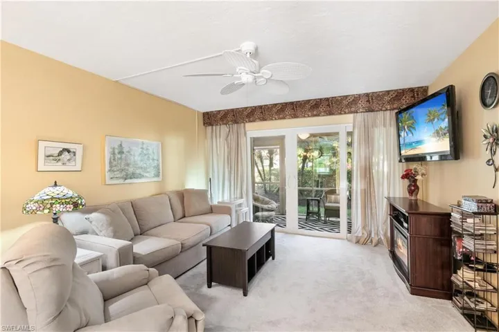 Carpeted living room featuring ceiling fan