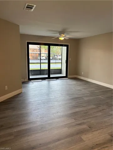 Living room featuring ceiling fan, wood-style flooring and sliding glass doors to screened porch