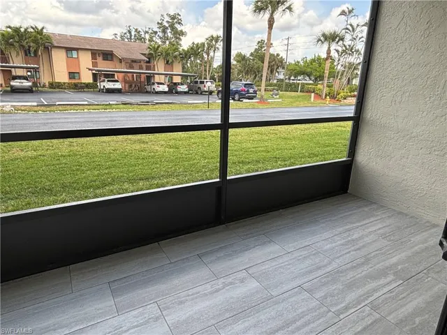 Screened patio off of living room with tile flooring