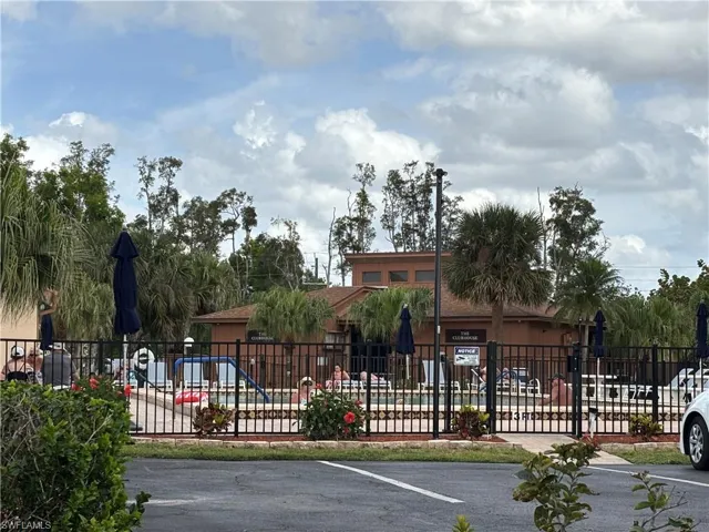 View of community pool and clobhouse with fence