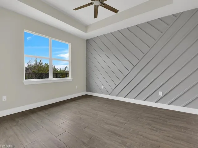 Spare room featuring baseboards, ceiling fan, and wood finished floors