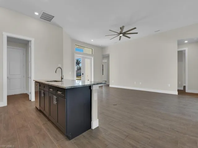 Kitchen featuring open floor plan, visible vents, and a sink