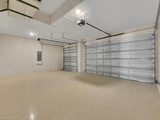 Garage featuring electric panel and a garage door opener