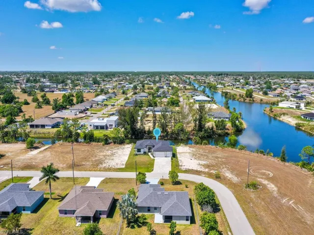 Birds eye view of property with a water view and a residential view