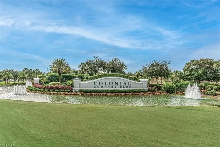Community / neighborhood sign with a yard and a water view
