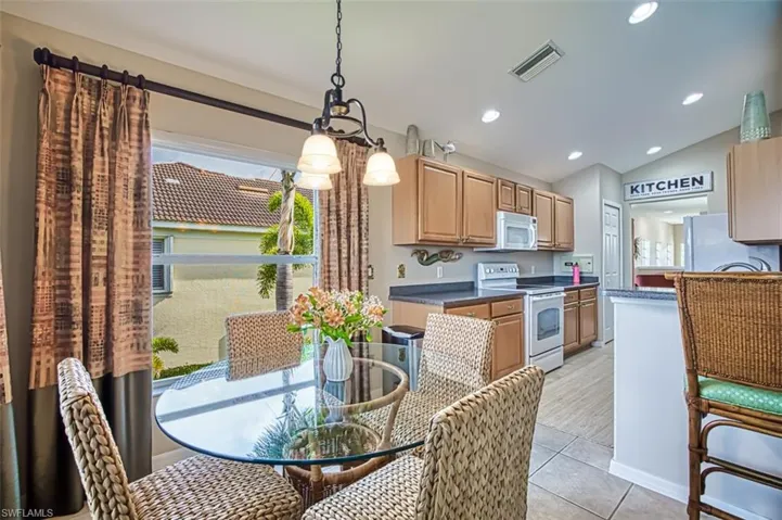 Dining space with vaulted ceiling, recessed lighting, and light tile patterned floors