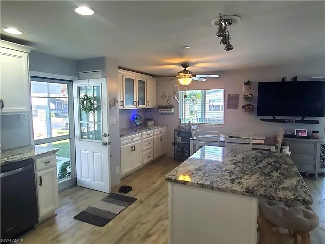 The Martha Stewart Kitchen featuring raised-panel wood cabinets, designer hardware, granite counters