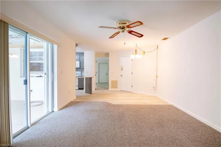 Unfurnished living room with light carpet and a ceiling fan