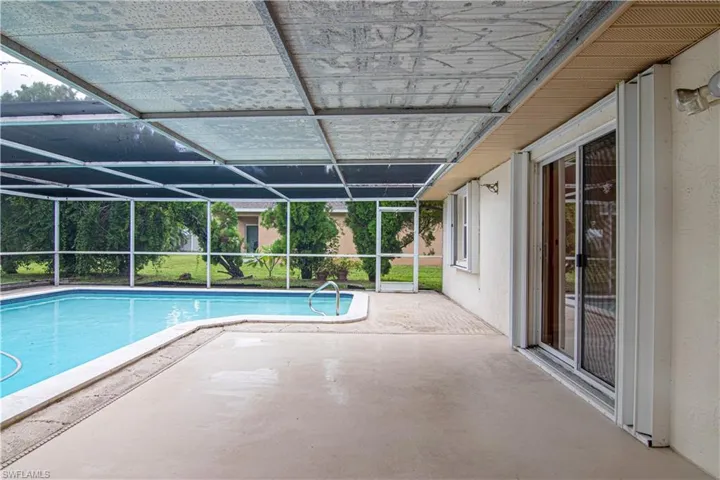 Outdoor pool featuring a patio, glass enclosure, and a sunroom