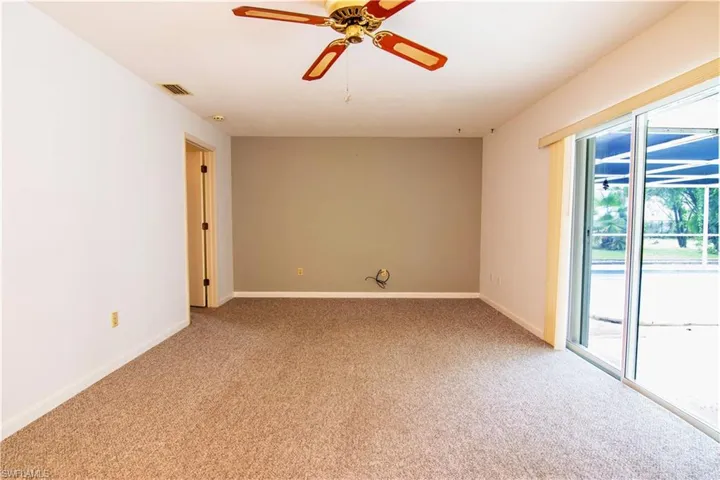 Spare room featuring ceiling fan and light colored carpet