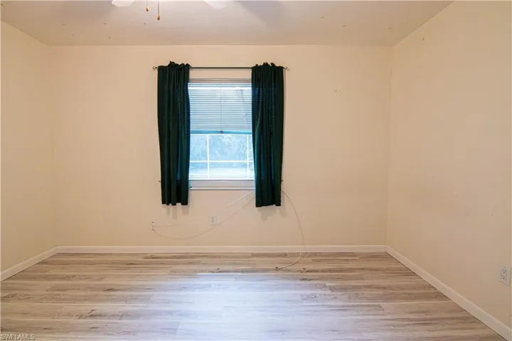 Empty room featuring light wood-type flooring and ceiling fan