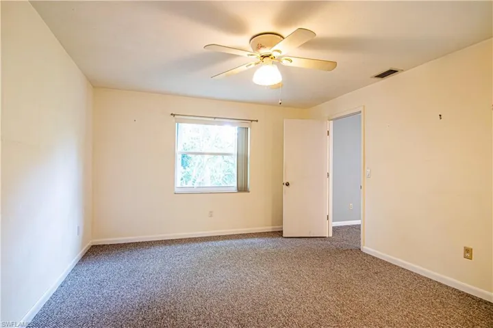 Carpeted spare room with baseboards and a ceiling fan