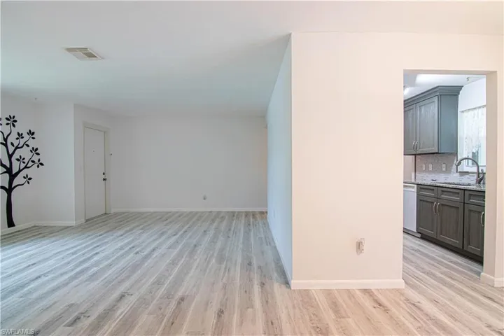 Unfurnished living room with light wood finished floors and baseboards