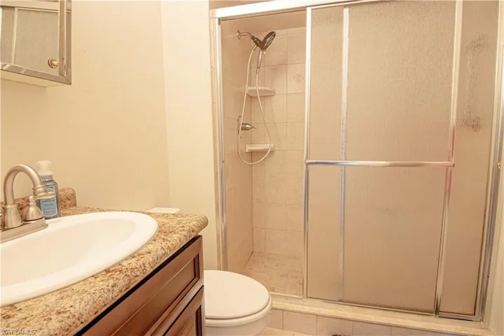 Full bath with a stall shower and vanity