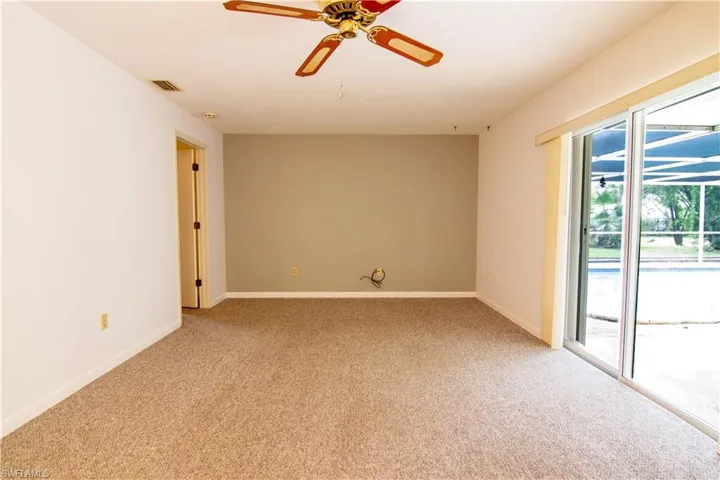 Spare room with a ceiling fan and light carpet
