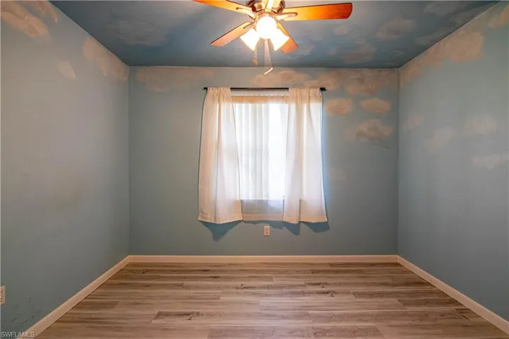 Empty room featuring light wood finished floors and ceiling fan
