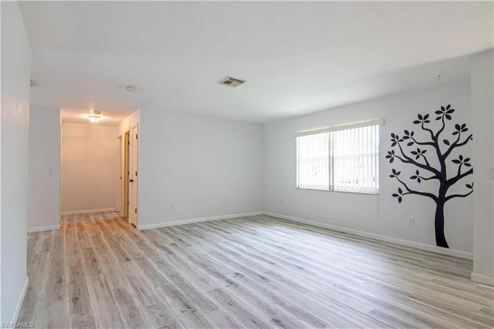 Unfurnished room with light wood-style flooring and baseboards