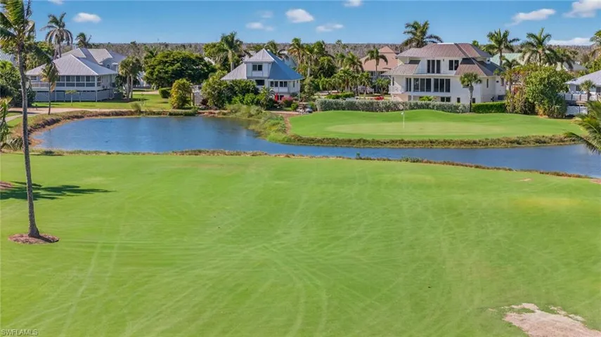 View of property's community featuring a water view, view of golf course, a yard, and a residential view