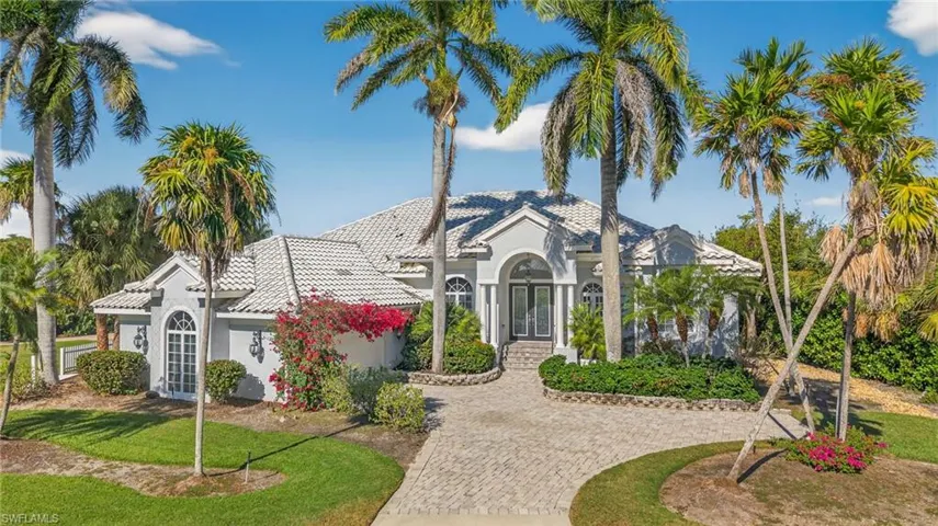 Mediterranean / spanish-style home with french doors, stucco siding, a tiled roof, and decorative driveway