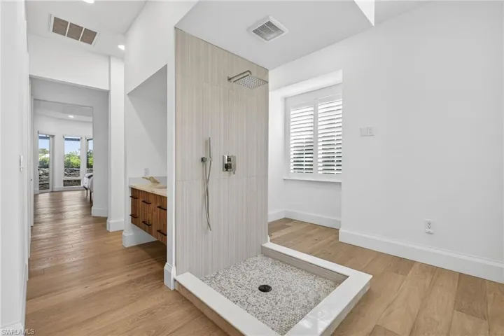 Bathroom featuring vanity, walk in shower, light wood-style floors, and recessed lighting