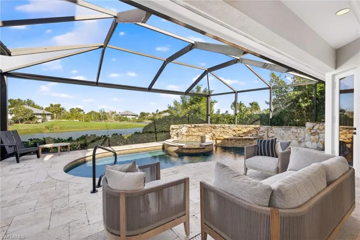 View of patio / terrace with glass enclosure, a sunroom, a water view, and a pool with connected hot tub
