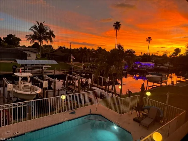 Waterfront property featuring a private boat lift, multiple dock spaces, and a swimming pool