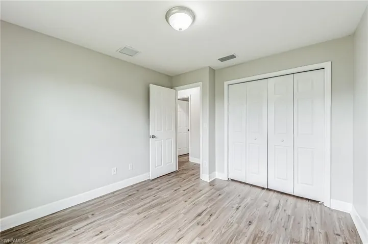Unfurnished bedroom featuring light hardwood / wood-style floors and a closet