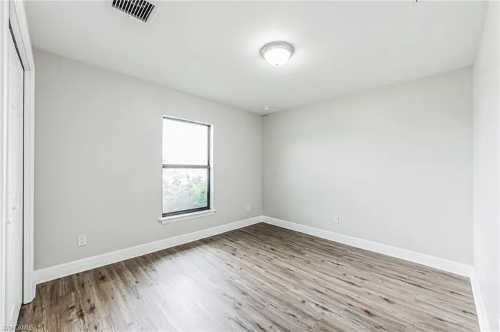 Empty room with hardwood / wood-style floors