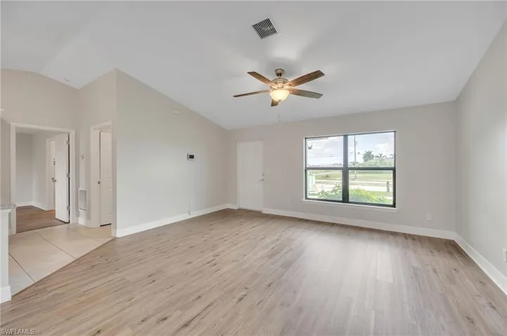 Spare room featuring vaulted ceiling, ceiling fan, and light hardwood / wood-style floors