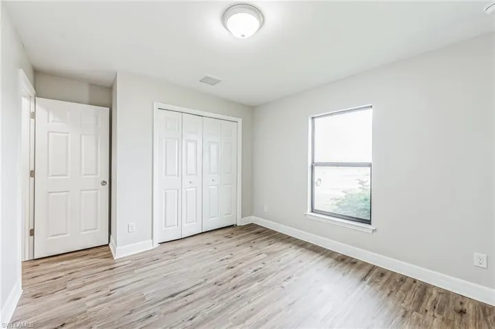 Unfurnished bedroom with light hardwood / wood-style flooring and a closet