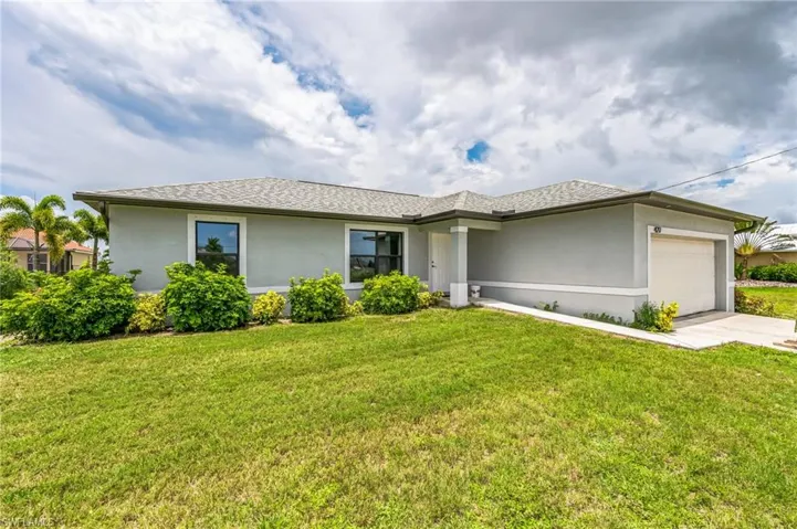View of front of home featuring a garage and a front yard