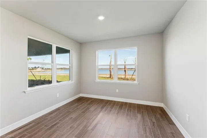 Unfurnished room with a water view and hardwood / wood-style flooring