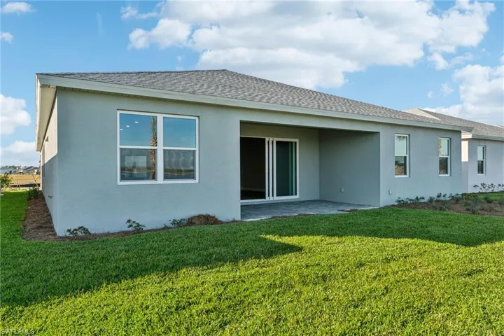 Back of house with a lawn and a patio area