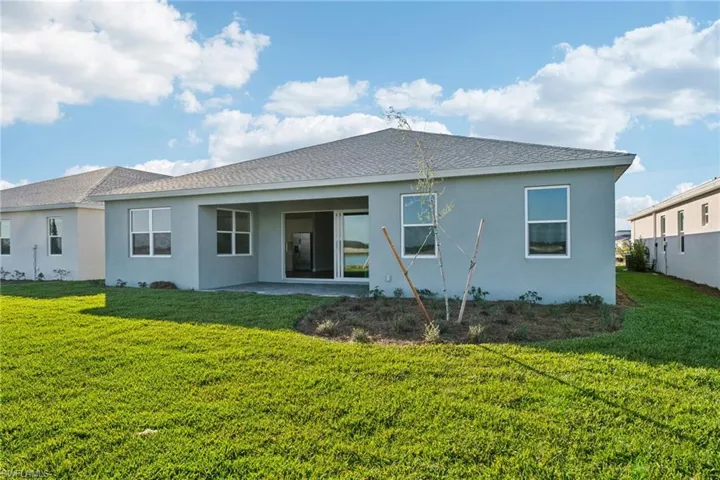 Rear view of house featuring a patio and a lawn