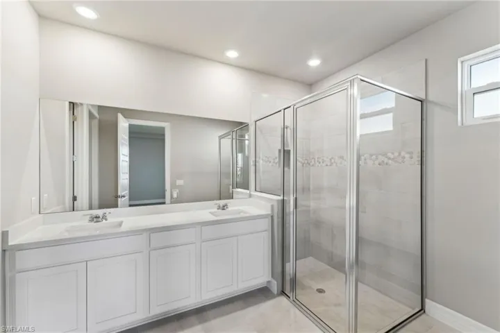 Bathroom with tile patterned floors, vanity, and an enclosed shower