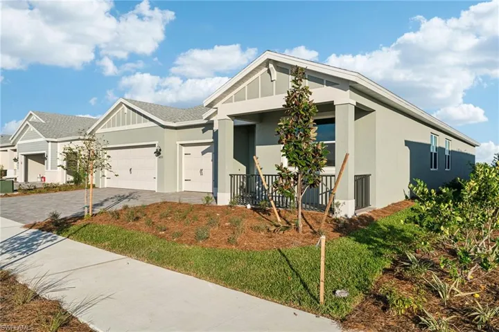 View of front of property featuring a garage and a front lawn