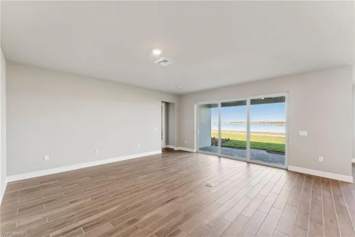 Spare room with a water view and light hardwood / wood-style flooring