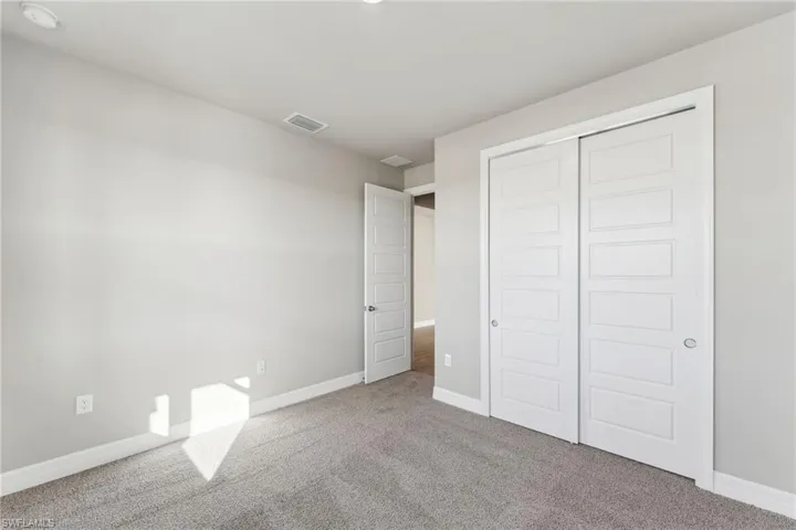 Unfurnished bedroom featuring carpet flooring and a closet