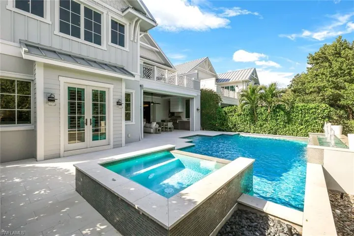 View of pool with an in ground hot tub, a patio, and french doors