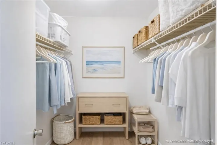 AI renovated/virtually staged. Walk in closet with light wood-type flooring