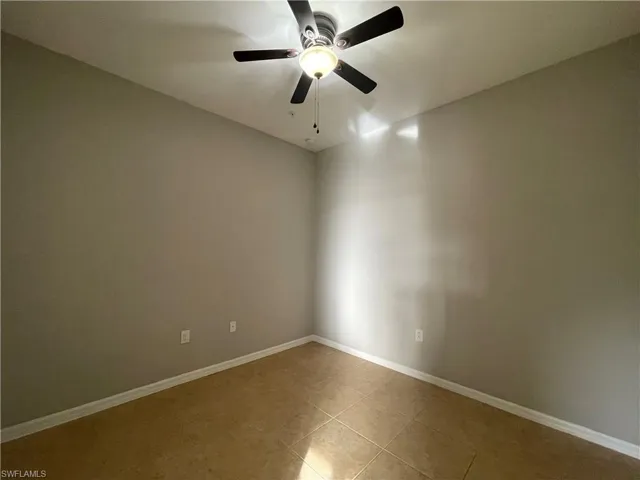 Tiled spare room with ceiling fan