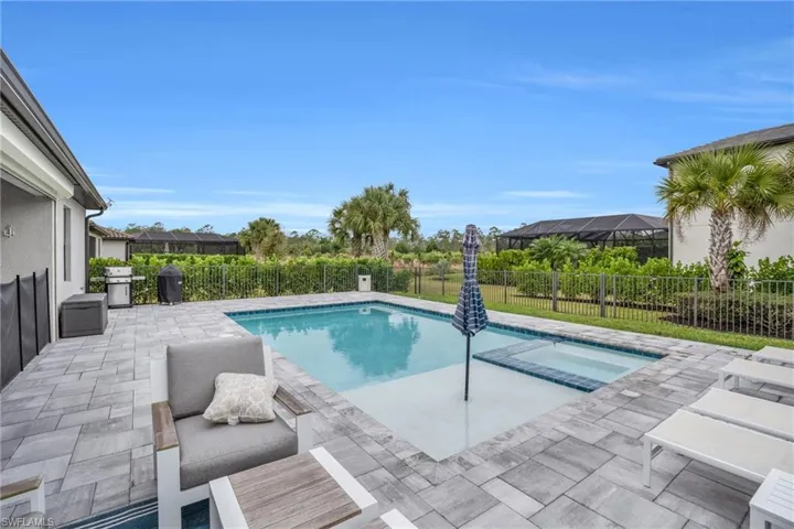 View of swimming pool with a patio area, a fenced backyard, grilling area, and a pool with connected hot tub